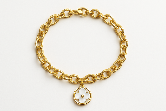 Professional studio photo of gold chain bracelet with white clover charm